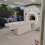  zdjęcie przedstawia technika radiologii wykonującego badanie rezonansu magnetycznego pacjentowi w Pracowni Rezonansu Magnetycznego. 